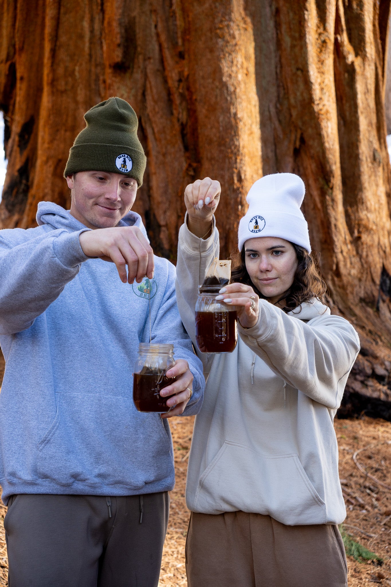 Nate and Emily, the founders of Bear Box Brew. Holding their brew bags in front of a redwood tree in Sequoia National Park.
